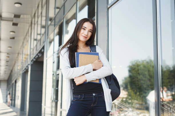 istock Student girl with books on university background 931687854
