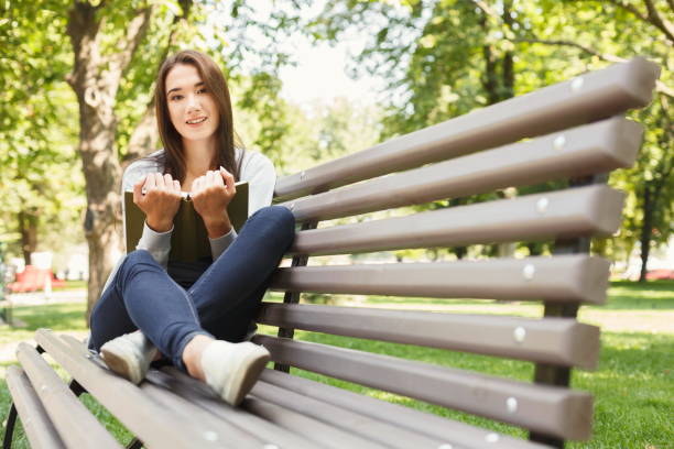 istock Young woman reading book in park copy space 931688698