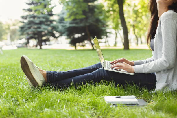 istock Young pensive woman using laptop in park 931688920