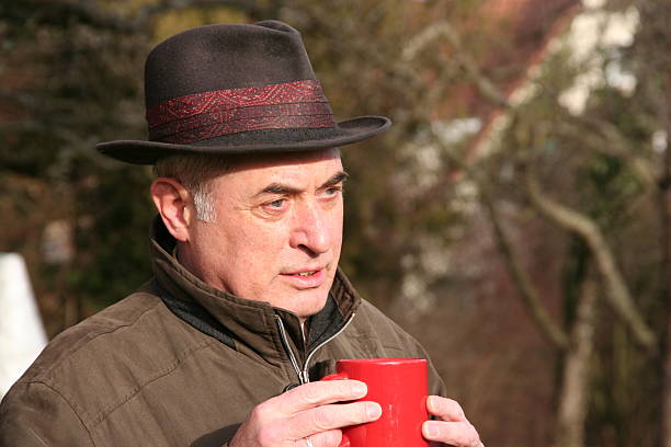 istock senior in nature holding a red coffee cup 93169112