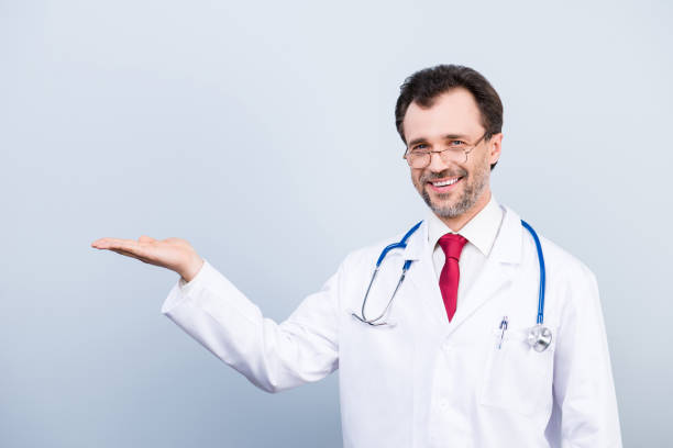 istock Successful specialist medico professional experienced successful qualified cheerful doctor wearing formal classic coat demonstrating empty blank space on hand isolated on gray background 931692196