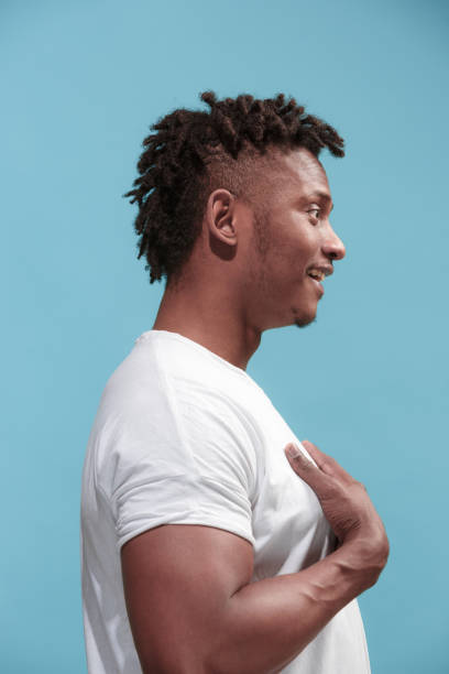 istock The surprised business Afro-American man standing and looking blue background. Profile view 931693894