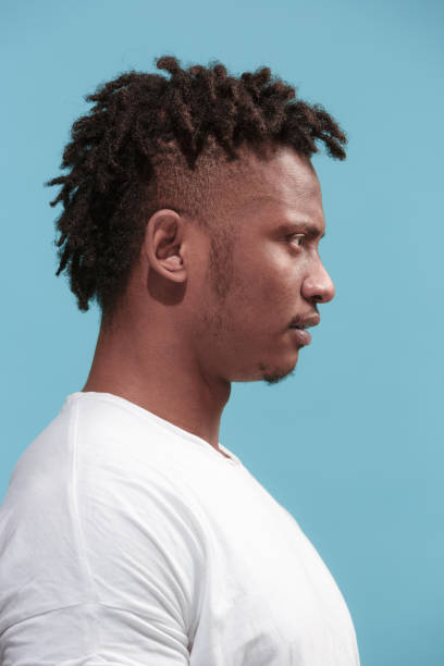 istock The surprised business Afro-American man standing and looking blue background. Profile view 931697010