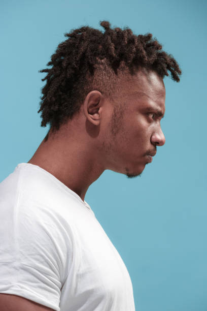 istock The young emotional angry afro man on blue studio background 931697548