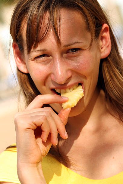 istock Girl eating tasty pineapple 93169821