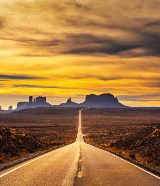 carretera del desierto hacia monument valley al atardecer - monument valley navajo mesa monument valley tribal park fotografías e imágenes de stock