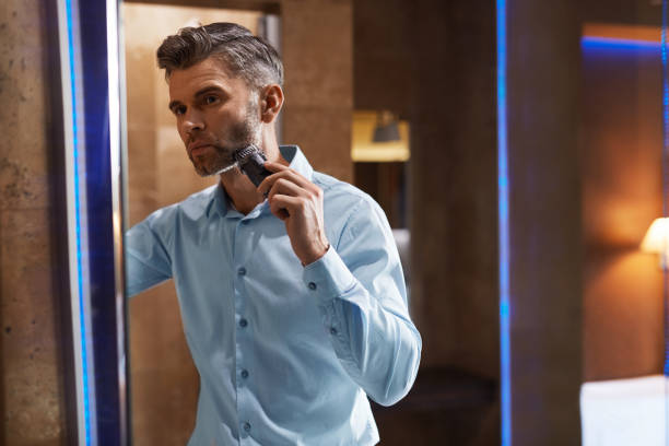 istock Man With Electric Razor Shaving Face In Bathroom. Men Grooming 931710604