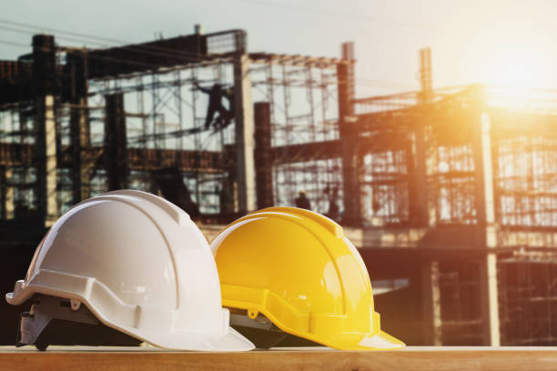 istock white and yellow safety helmet in construction side with sunset 931710806