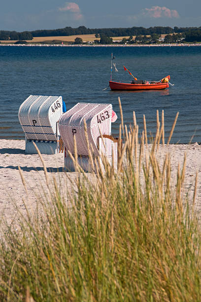 istock Two beach chairs and red fishing boat 93171425