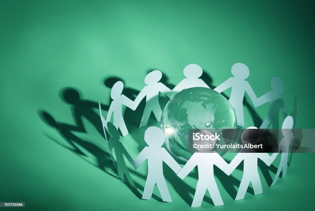 group of paper men standing around the glass globe business background.group of paper men standing around the glass globe Adult Stock Photo