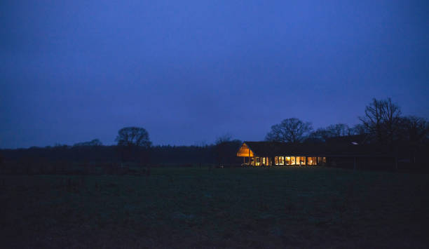 istock Countryside winter landscape with illuminated house at dusk. 931728484