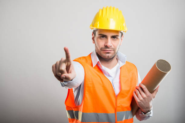 istock Portrait of young architect holding blueprints making wait gesture 931733598