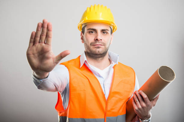 istock Portrait of young architect holding blueprints making stop gesture 931733712