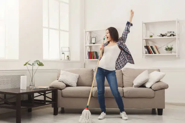 Photo of Happy woman cleaning home with mop and having fun