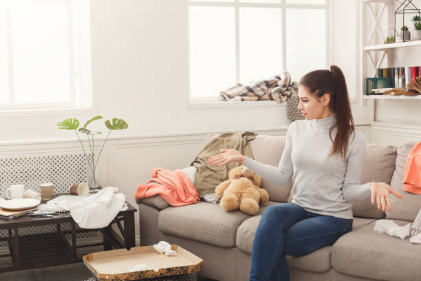 istock Desperate woman sitting on sofa in messy room 931743732