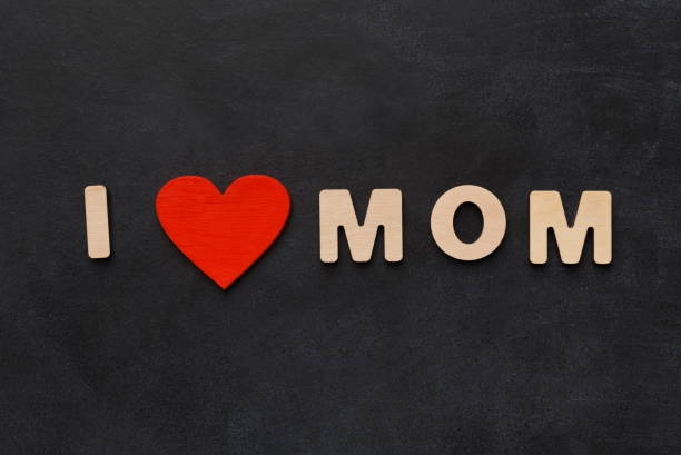 istock Love mom phrase written on black with wooden letters 931744398