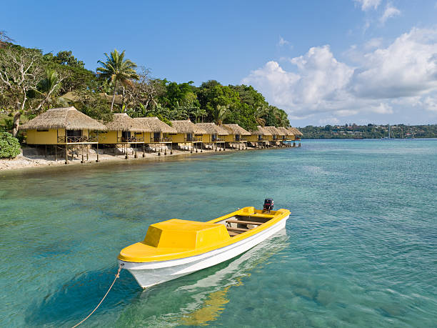 bateau jaune devant iririki, vanuatu - pacific ocean tourist resort day reflection photos et images de collection