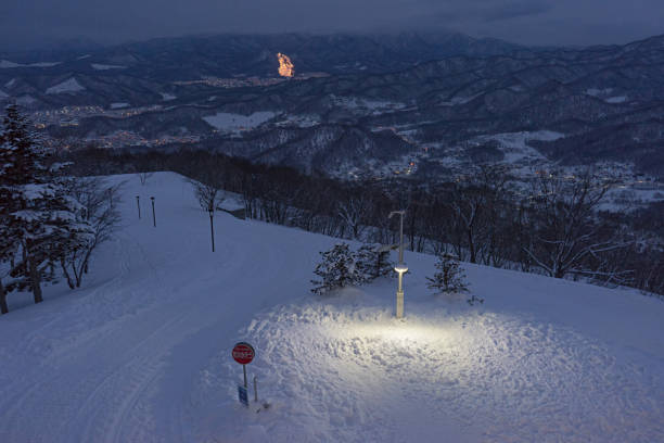 街路灯や町のライトと山の背景に雪 - 北海道 札幌 道路 ハイアングル ストックフォトと画像