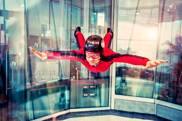 Free flight in the wind tunnel. Flight in the Indoor Skydiving. The man is flying in the wind tunnel. Free flight in the Simulator of Free-fall. Aerodynamic tunnel. The wind tunnel is a device used for free floating. skydiving stock pictures, royalty-free photos & images