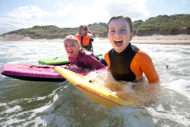istock Girls Bodyboarding in the Sea 931753674