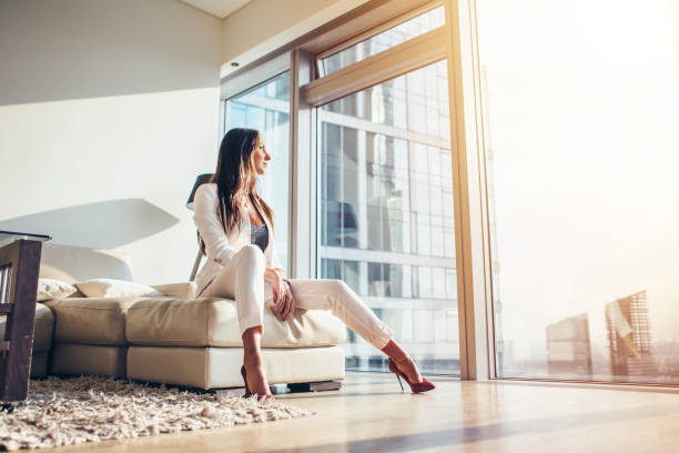 istock Woman sitting on a sofa at modern apartment 931756246