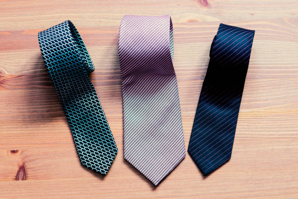 istock three men's tie rolled into a roll on a wooden background 931756484