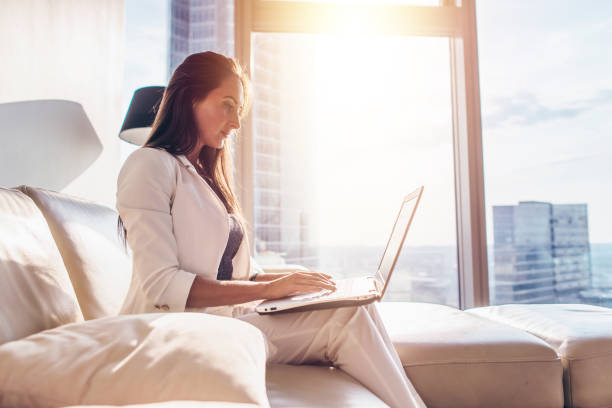 istock Side view of successful young female working on laptop 931756656