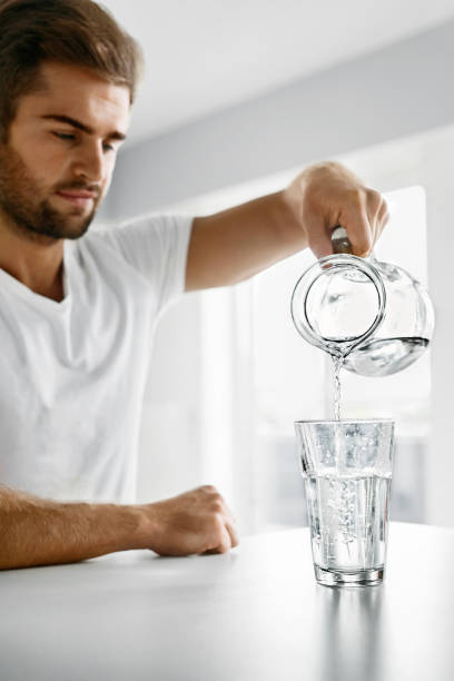 istock Drink Water. Close Up Man Pouring Water Into Glass. Hydration 931762014