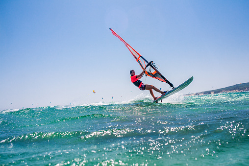 Group of people doing kitesurfing and windsurfing on sea.