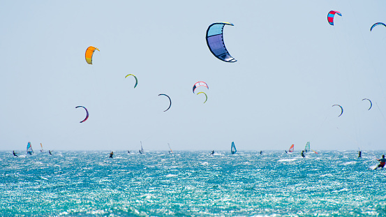 Young woman professional kiter performs ride beautiful background of the sunset and sea.