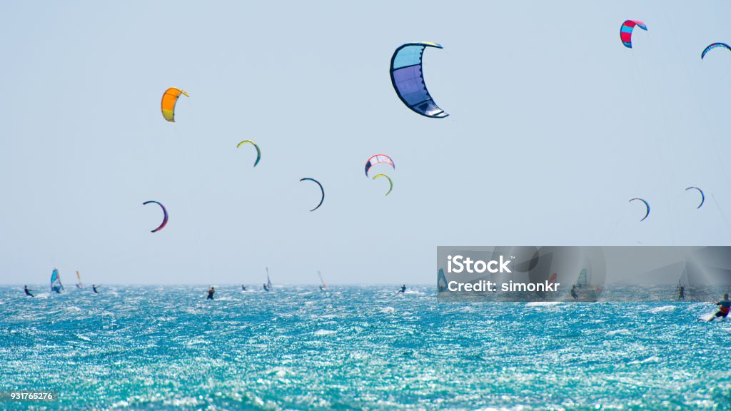 People doing kitesurfing and windsurfing Group of people doing kitesurfing and windsurfing on sea. Kiteboarding Stock Photo