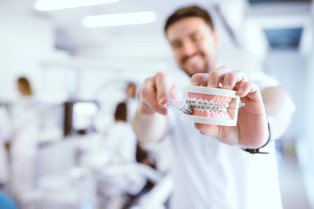 dentist shows the wright way to brush your teeth with braces