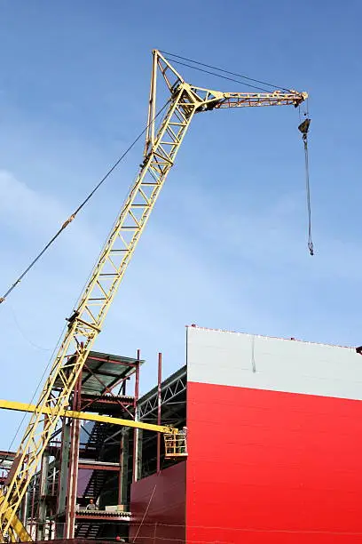 hoisting crane on building of the red office block
