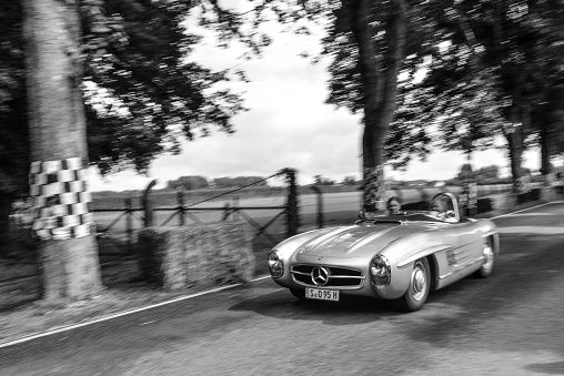 Mercedes-Benz 300 SLS Roadster classic lightweight racing car driving on a country roadMercedes-Benz 300 SLS Roadster classic lightweight racing car driving on a country road. The SLS is a lightweight and more powerful edition of the famous 300 SL Gullwing sports car. The car is doing a demonstration drive during the 2017 Classic Days event at Schloss Dyck.