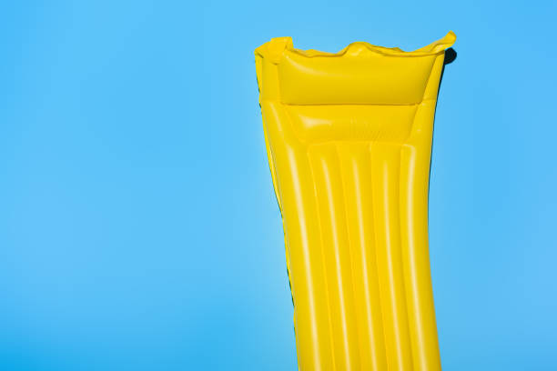 istock yellow inflatable mattress on blue with copy space 931776126