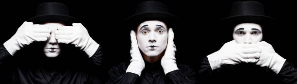 istock mime showing see no evil, hear no evil, speak no evil isolated on black 931777220
