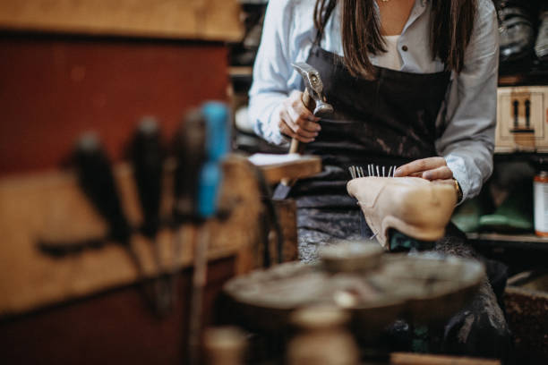 female cobbler putting sole on shoe - independence business women manual worker imagens e fotografias de stock