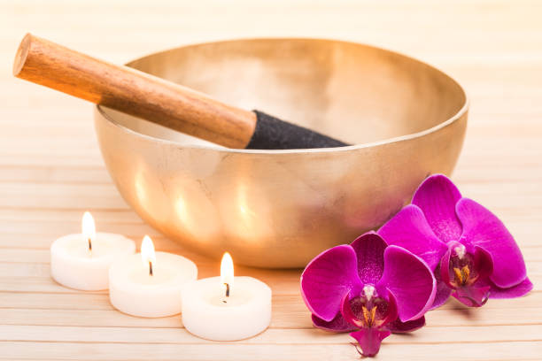 istock Singing bowl with burning candles and orchid flowers 931779274