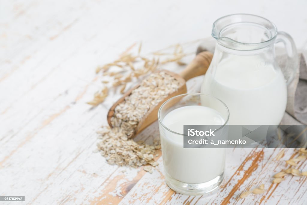 Lait d’avoine en verre et jar sur fond de bois - Photo de Lait libre de droits