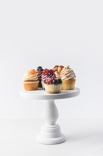 top view of various sweet cupcakes on cake stand isolated on white