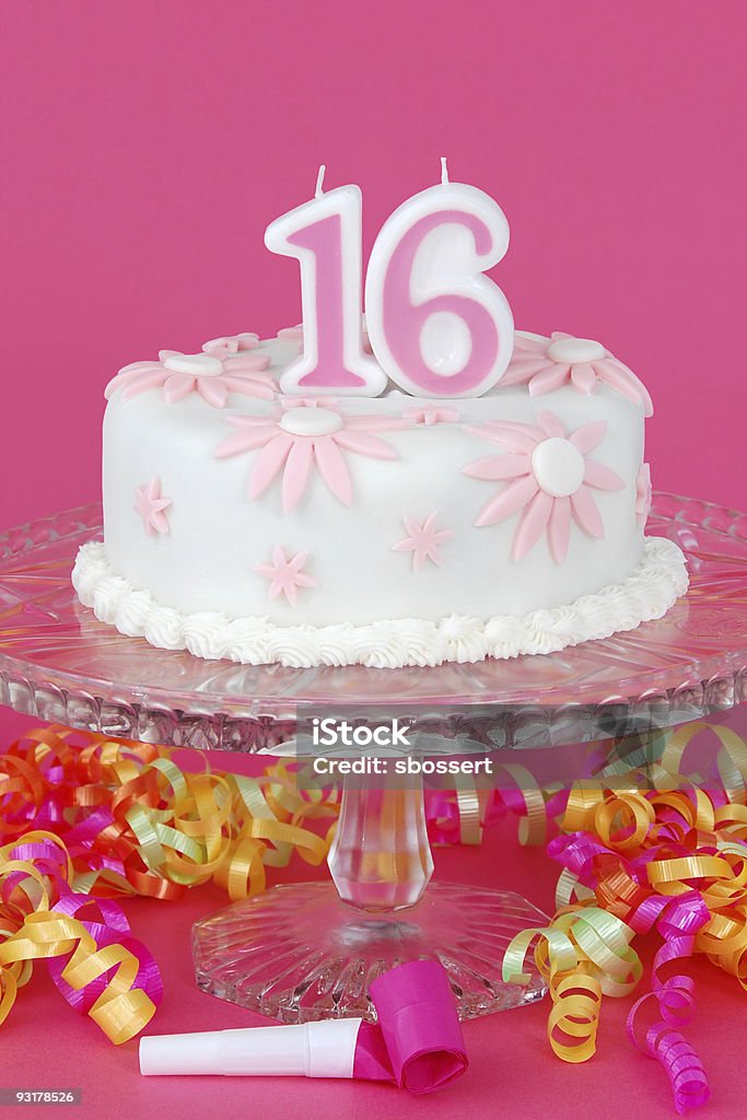 Sweet Sixteen Cake A "Sweet Sixteen" birthday cake decorated with pink and white fondant daisies. Candle Stock Photo