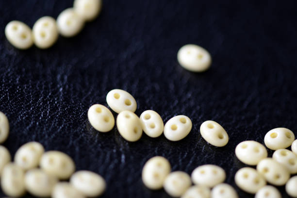 Scattered twin beads green color on a dark surface close up