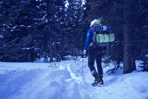 夜に雪の中をバックパックを背負って男 - camping hiking montana night ストックフォトと画像