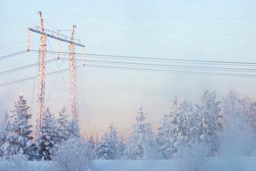 High voltage power transmission towers in fog on mountain