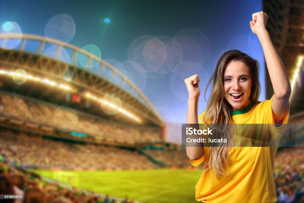 Brazilian fan cheering at the stadium The Brazilian fan cheering at the stadium encouraging the Brazilian Soccer players - Evening - Copy space on left side Fan - Enthusiast Stock Photo