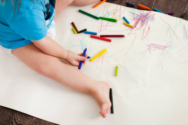 istock the child draws wax crayons on the floor 931804782