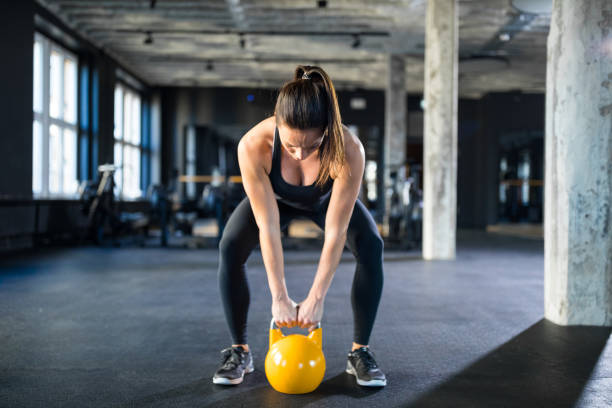 jovem mulher levantamento kettlebell no ginásio - cleavage - fotografias e filmes do acervo