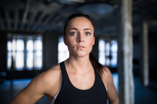 Portrait of determined athlete in gym. Close-up of confident young female in health club. She is in sportswear.