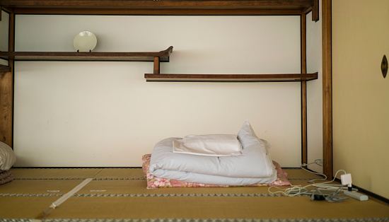 View of guesthouse bedroom near Monks leaving quarters at Chion-ji temple in Kyoto, Japan. It is traditional way with sleeping on tatami. In day time the bad is nicely placed.