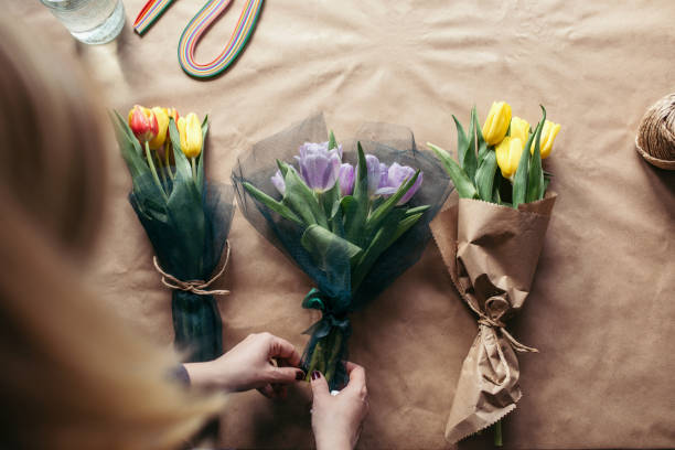 istock Young girl makes a tulip bouquet 931814812